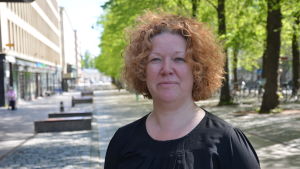 Maria Hällund Maria Hällund står på gågatan i Vasa. Hon har rött, lockigt hår och en svart klänning på sig.