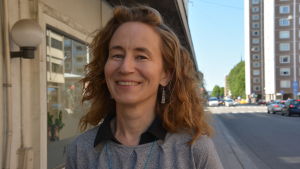 Projektledare Anna Mikkonen är nöjd och hoppas andra ska kunna dra nytta av de erfarenheter förbundet för mödra- och skyddshem har. Leende kvinna står på Trädgårdsgatan i Åbo med långt brunt hår.