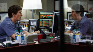 The Big Short. Christian Bale sitter vid datorskärmar och undersöker börskurserna.