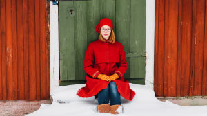 Maria Turtschaninoff sitter vid en grön dörr.