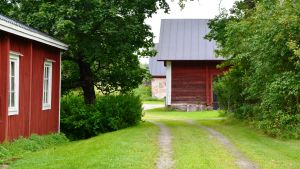 Den gamla bagarstugan till vänster torde vara från slutet av 1700-talet. Längst bort ligger den äldsta delen av ladugården. Den smala vägen är gamla Helsingforsvägen. Den gamla bagarstugan och ladugården på Karleby gård.