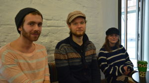 Jonatan Finell, Oscar Karlsson och Linnéa Hasselblatt. Jonatan Finell, Oscar Karlsson och Linnéa Hasselblatt sitter på café. Finell har en randig tröja, Kalrsson har en yllekofta och Hasselblatt har en randig ylletröja på sig. Alla är i 20-årsåldern.