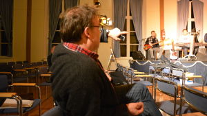 Henrik Grönroos regisserade också revyn för åtta år sedan. Man pekar på orkester.