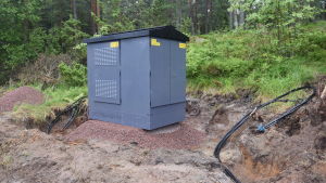 En ny transformator för jordkablarna. En av Carunas nya transformatorer för jordkablar. En grå låda med tak på.