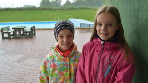 Mathilda (till vänster) och Felicia Nyman tycker det är roligt att gå i simskolan. barnen mathilda och felicia nyman står framför poolen vid friluftsbadet i solf