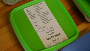 Burken innehåller ett smakprov av ordlingen Los Pirineos kaffebönor. På lappen syns allt från ursprungsnationen till odlarens namn och vad kaffebönorna smakar. En ask med kaffebönor.