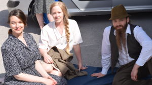 Jenny Moberg från Fiskars, tillsammans med Jonna Tynkynniemi och Samuli Sundström. De har klätt på sig 1940-talsdräkterna och väntar på att inspelningen ska börja. Ännu vet de bara att de ska vara dansare, hurudan dans det blir är ännu lite oklart. Statister på filminspelning i Fiskars.