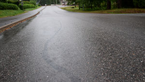 Mopedisterna har lämnat efter sig märken i asfalten på Sockenvägen. En väg som är våt av regn. I asfalten syns märken efter att en moped har bromsat.