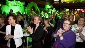Glada människor applåderar på De grönas valvaka i Helsingfors.