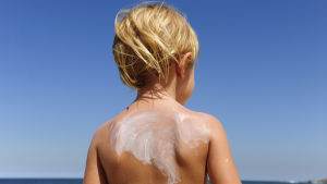 Är barnen tillräckligt små är de oftast inkluderade i en förälders försäkring Ett barn i solen på en badstrand