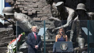 USA:s president Donald Trump står på scenen i Warszawa tillsammans med sin fru Melania. USA:s president Donald Trump står på scenen i Warszawa tillsammans med sin fru Melania. I bakgrunden statyer på soldater.