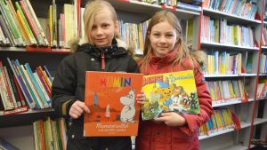 Åttaåriga Christa Julin och Neela Nyman tänker låna en Mumin- och en Bamsebok. Christa Julin och Neela Nyman lånar böcker från Sibbos bokbuss.
