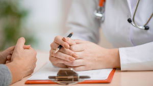 Enligt läkareden ska läkare inte diskriminera någon, betonar Kati Myllymäki, verksamhetsledare för Läkarförbundet. Närbild av händerna av en läkare och dennes patient. De sitter mot varandra och samtalar.