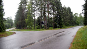 Mopedisterna vansinneskör bland annat i korsningen mellan Sockenvägen och Lindsbybacken. Ett foto på en korsning där asfalten är våt av regn.