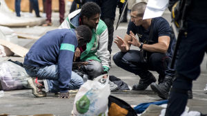 En mgirant tas om hand av brandkår efter att han svimmade när kravallpolis sköt tårgas mot det provisoriska lägret där främst sudaneser och eritreaner bodde i norra Paris i augusti. En mgirant tas om hand av brandkår efter att han svimmade när kravallpolis sköt tårgas mot det provisoriska lägret där främst sudaneser och eritreaner bodde i norra Paris i augusti.