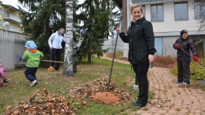 Mira Pajunen hjälper till med krattningen. Avdelningsskötare Mira Pajunen krattar tillsammans med barn och unga.