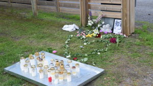 Blommor och ljus utanför bostaden till den unga flickan som blev mördad i Ekenäs.