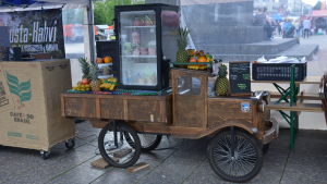 På marknaden säljs både sött och salt. en kärra med en massa frukter såsom ananas, banan och apelsiner