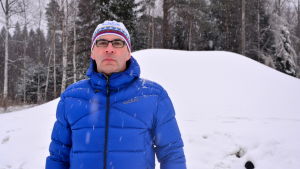 Hannu Riiki, ordförande för Malax IF Skidning. Hannu Riiki, ordförande för Malax IF Skidning, står framför en stor hög med snö.