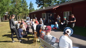 Sång och musik hör till programmet. grupp med människor sitter och lyssnar