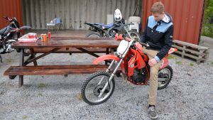 Juho Kivinen på den moped som ska säljas för ett gott ändamål då den är färdigt reparerad. Juho Kivinen vid mopedverkstaden i Box i Sibbo