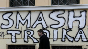 Många greker anser att den så kallade trojkan d.v.s. EU-kommissionen, Europeiska centralbanken och IMF, drivit på en alltför hård sparpolitik i landet. Graffiti i Aten.