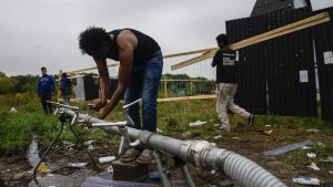 Man tvättar händerna vid flyktinglägret "Djungeln" i Calais i Frankrike. En man tvättar händerna i flyktinglägret "Djungeln" i Calais Frankrike