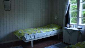 Sängarna på Lillholmen är bäddade med Muminlakan. Sovrummet på Lillholmen. Sängen är bäddad med Muminlakan.