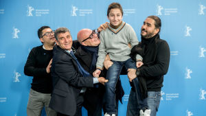 Fuocoammare-teamet inför filmens världsurpremiär i Berlin. I mitten läkaren Pietro Bartolo, regissören Gianfranco Rosi och 12-åriga Samuele, en av dokumentärfilmens huvudpersoner Personer bakom filmen Fuocoammare, regissören Gianfranco Rosi i mitten