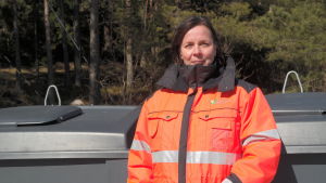 Cati Huhta är invånarservicechef på Sydvästra Finlands avfallsservice. Cati Huhta står vid ett avfallskärl i Kirjais i Nagu