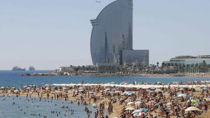 Stränderna i Barcelona är fulla av turister och lokala under sommaren. Folk på stranden i Barcelona