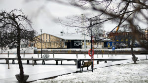 Nattklubben Ettan finns i Hamnmagasinet i Norra hamnen i Ekenäs. En vy över en hamn i vinterskrud. I bakgrunden syns en gul gammal magasinbyggnad.