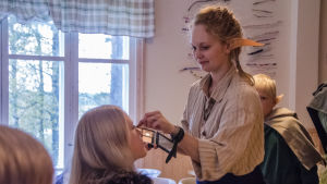 Tina Backström sminkar en av deltagarna i lajvet. Deltagare i levande rollspel sminkas.