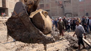 Ett enormt huvud som troligtvis tillhör Ramses II lyfts upp av den grävskopa.