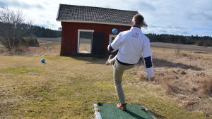 Med så få sparkar som möjligt ska bollen fås in i hålet. Banorna har också inslag av minigolf med olika slag av hinder på vägen. På bilden försöker Sebastian Lindberg sparka bollen genom det lilla huset. Ung man försöker sparka en boll genom ett litet hus.