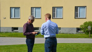 Matti Salminen i diskussion med Carl-Johan Strömberg Direktör Matti Salminen på Statens skolhem diskuterar med direktör Carl-Johan Strömberg på Lagmansgården ute på gården på Lagmansgården i Pedersöre.