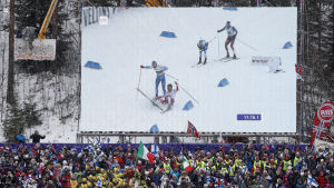 Tiotusentals åskådare följde med det dramatiska avgörandet på plats. Iivo Niskanens och Emil Iversens olycka på stora videoskärmen, VM 2017.