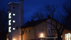 Brandkårshuset i Pojo är i händelsernas centrum på lördag. en upplyst byggnad med torn