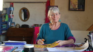 Antonia Ringbom vid arbetsbordet i studion. Animationsfilmaren Antonia Ringbom sitter vid ett arbetsbord i sin ateljé