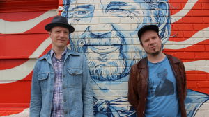 Markus Nordenstreng (vas.) ja Tuomo Prättälä ehtivät käymään Austinissa myös legendaarisen texasilaisen Willie Nelsonin keikalla. Markus Nordenstreng ja Tuomo Prättälä seisovat seinän edessä.