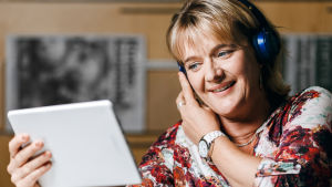 Tongåvan on lähettänyt toivemusiikkia ja terveisiä jo yli 50 vuoden ajan ja kerännyt varoja hyväntekeväisyyteen. Kuvassa toimittaja ja juontaja Camilla Kivivuori. Camilla Kivivuori pitää kiinni tablettilaitteesta ja katsoo siihen kuulokkeet korvilla