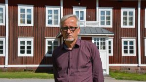 Matti Salminen Direktör Matti Salminen på Statens skolhem står framför ett av de hundra år gamla husen på Lagmansgården i Pedersöre.