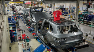Arkivbild. Fabriken i Nystad tillverkar bilar av flera olika märken och modeller. I år kommer fabriken också att börja producera bilbatterier. Auton runko liukuhihnalla. työmeis kattoluukussa.