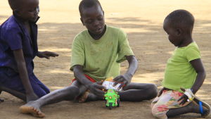 Francis systerson, sonen John och dottern Felicity leker med plastbilen som Francis hämtade från Kampala. barn i norra uganda