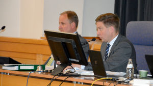 Stadsdirektör Tom Simola (t.v) och stadsfullmäktiges ordförande Thomas Blomqvist (SFP). Ordförande Thomas Blomqvist vid Raseborgs stadsfullmäktiges presidium. I bakgrunden skymtar stadsdirektör Tom Simola.