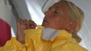 De senaste fem veckorna har Tiina Saarikoski vistats på ett av världens för tillfället farligaste ställen, mitt i det eboladrabbade Kenema i Sierra Leone. Här klär hon på sig skyddsdräkten innan hon börjar jobba. Tiina Saarikoski klär på sig en skyddsdräkt