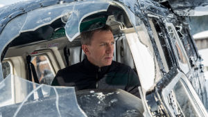 Bond istuu lentokoneessa, jonka ikkuna on rikki.