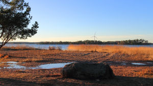 Exempel på hur ett litet vindkraftverk kunde se ut. Möllan på bilden är 30 meter hög, placerad på Stora Iglo, sett från Kallviksuddens badstrand. Illustration av lokalproducerande vindkraft på Stora Iglo, sett från Kallviksuddens badstrand.