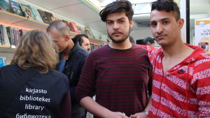 Motaz och Hussein i bokbussen. Motaz och Hussein i bokbussen i Knäcktbro i Esbo.