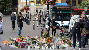 Blommor och ljus vid den plats där en person misshandlades till döds i Helsingfors.